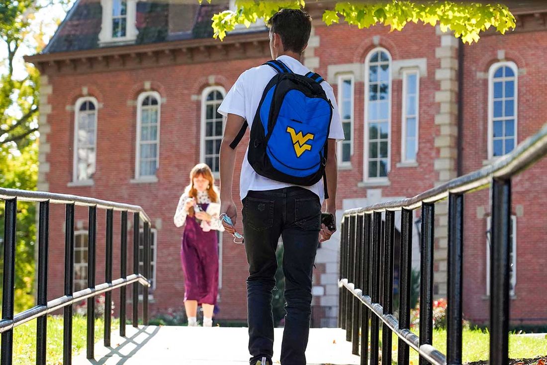 student with backpack walking on campus